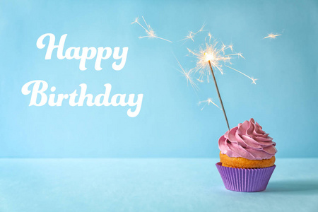 美味的纸杯蛋糕，带火花，文字，生日快乐，蓝色背景