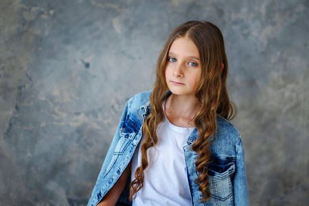 美丽的吉尔美丽的女孩10岁的模型在灰色背景。10岁的模型在灰色背景。