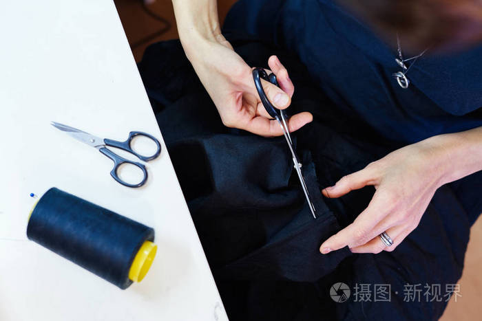 女裁缝的工作场所裁缝师用剪刀裁剪衣服细节裁缝店剪裁贴身