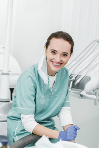 戴牙套的美丽牙医在牙科诊所微笑