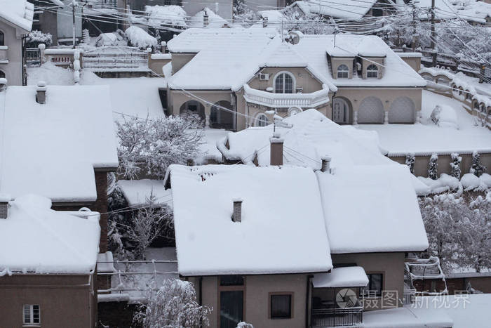 美丽的冬天,房子和建筑物的屋顶覆盖着大雪. 在下雪的