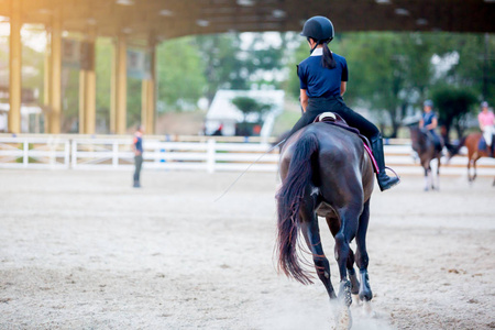 女人学骑马。 年轻女子喜欢骑马。