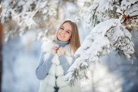 阳光明媚的冰冻天，白雪森林中美丽的年轻女子的户外肖像。