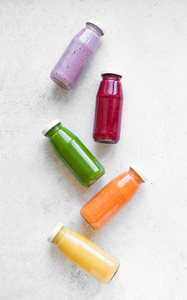 各种冰沙或果汁瓶健康饮食排毒素食清洁食品概念顶部视图复制空间。 白色背景上五颜六色的冰沙。