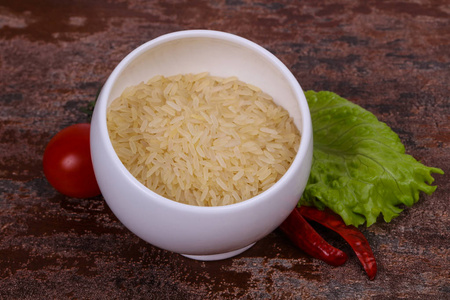 生的，未煮熟的米饭，放在碗里，放胡椒和沙拉叶