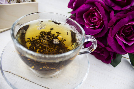 茶。 绿茶。 草药茶。 薄荷叶。 有苹果味道的茶。 茶杯里的茶，苹果花和树叶干茶切片石灰。 在餐厅或茶室的石板板上放着草药茶和薄
