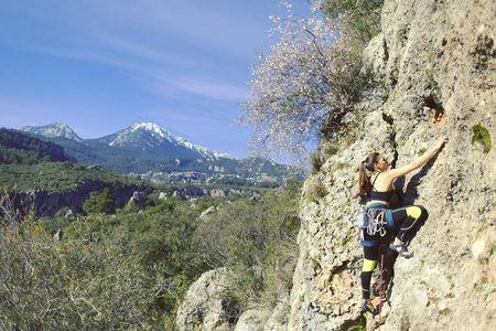 女孩攀岩者爬上悬崖上艰难的路线。