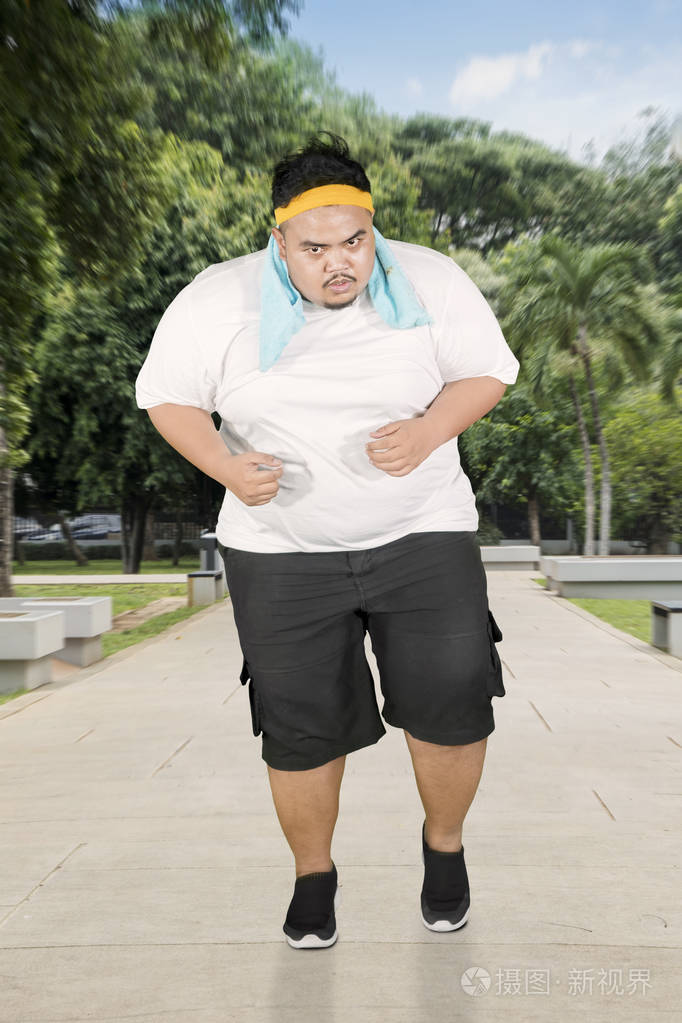 一个穿运动装的肥胖男人在公园里做跑步运动的肖像