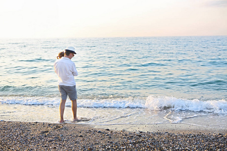 父亲和他的小女儿在日落时分沿着海滩散步