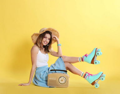 带着溜冰鞋和彩色背景复古收音机的年轻女子