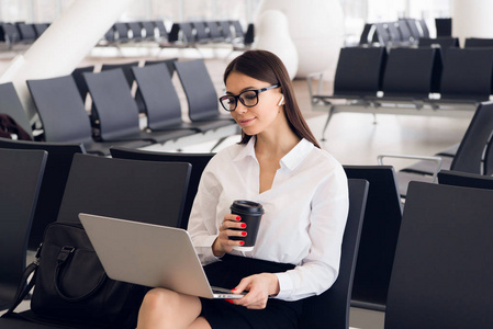 年轻优雅的女商人在国际机场航站楼, 在等待航班时使用笔记本电脑