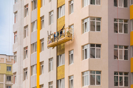 建筑商在高层住宅建筑的外墙上作画