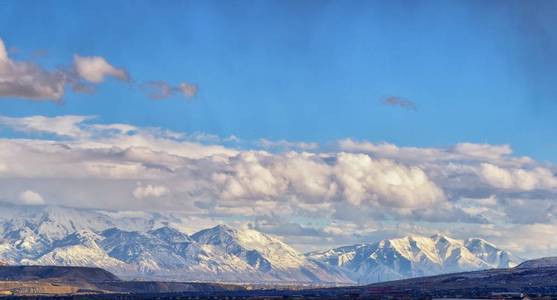 冬季雪顶全景山前岩石山，大盐湖谷和云景从巴克斯公路。 犹他州美国。