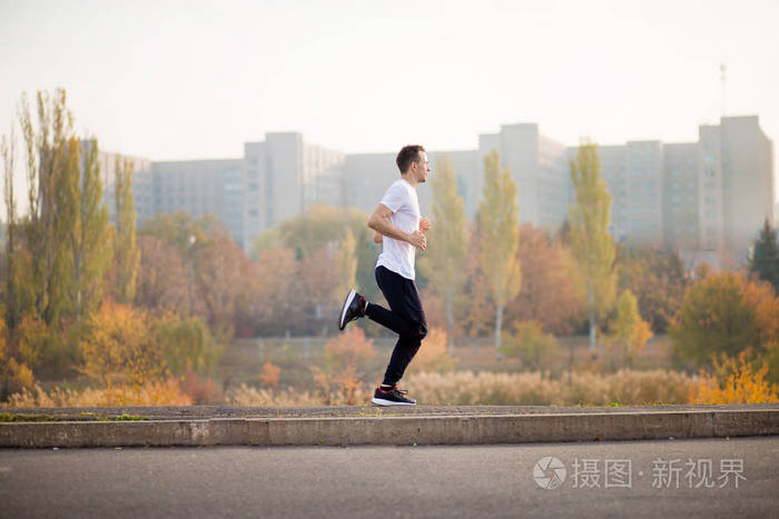 男人在秋天的早晨跑步. 健康生活方式概念照片-正版