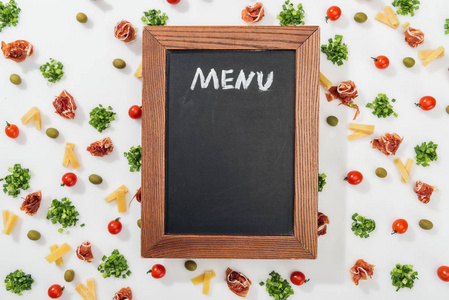 粉笔板俯视图，菜单上刻有橄榄火腿绿色植物切碎的奶酪和樱桃西红柿