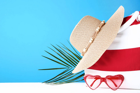 带帽子和太阳镜的夏季包，蓝色背景
