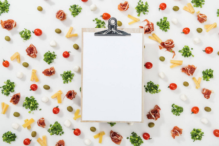 空剪贴板，菜单字母排列在橄榄布托青葱切奶酪和樱桃番茄之间
