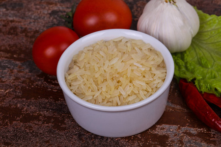 生的，未煮熟的米饭，放在碗里，放胡椒和沙拉叶