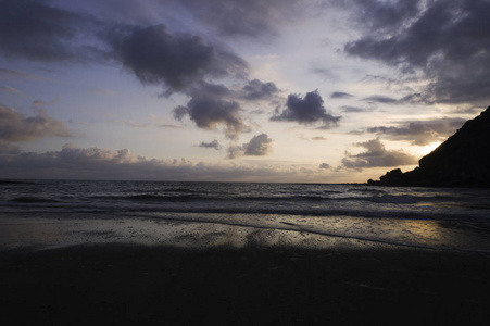 美丽的夏天，金色的日落在黑海之上，平静的波浪和海滩上的阳光反射。 西班牙埃斯帕萨海滩阿斯图里亚斯。