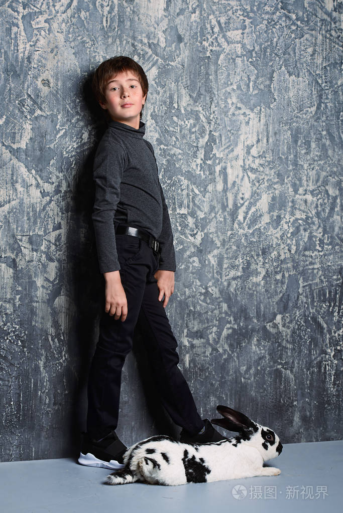 s fashion. modern boy is posing in dark clothes and hat with rab