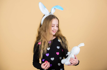 孩子们的复活节活动。假日兔子小女孩与长兔子耳朵。孩子可爱的兔子服装。孩子拿着嫩软兔玩具。复活节就要到了庆祝复活节。快乐的童年