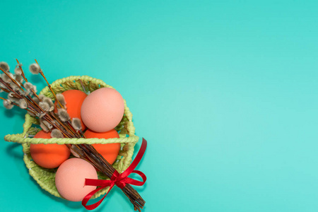 篮子里画着绿松石背景上的鸡蛋。 快乐复活节概念