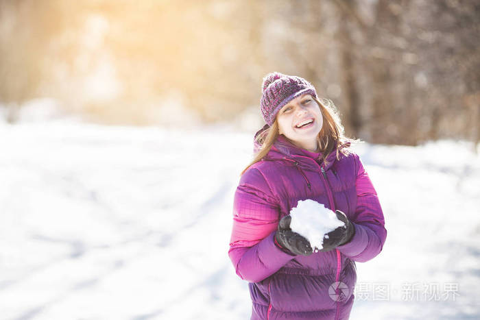 可爱开朗的女孩手里拿着雪