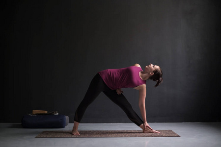 女孩站在 utthita trikonasana, 延长三角形姿势