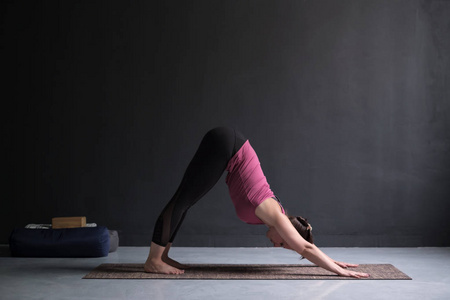 做瑜伽练习向下面对狗姿势的妇女, adho mukha svanasana