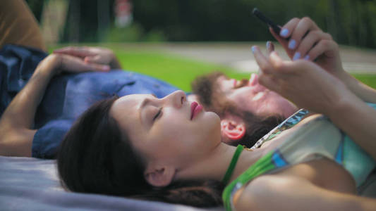 一对年轻夫妇休息和在公园聊天