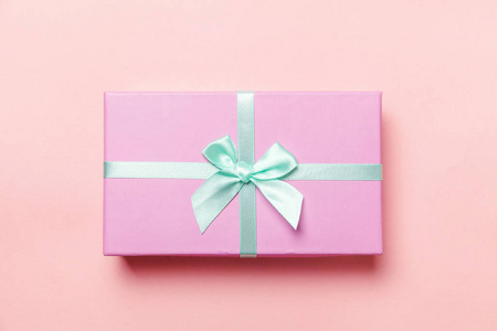 圣诞节新年生日情人节庆祝礼物浪漫的概念。 小礼品盒包装的粉红色纸隔离在粉红色的糊彩彩色潮流背景上。 平躺顶视复印空间