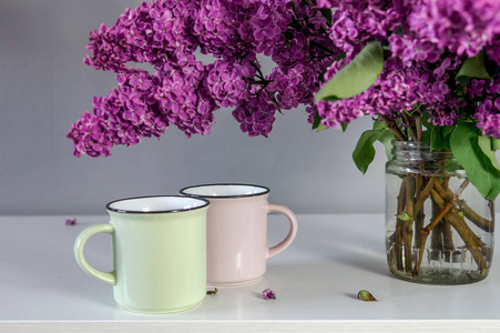 桌子上的紫丁香和杯子