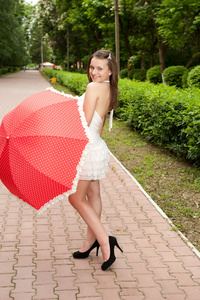 年轻的女孩用伞在公园