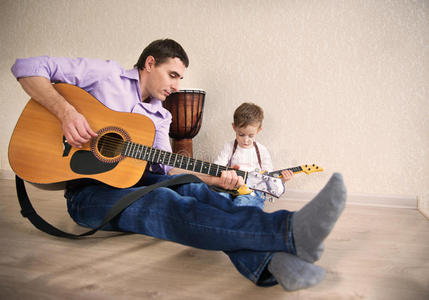 年轻的父亲和小儿吉他图片
