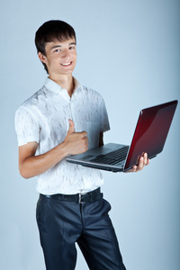 英俊的年轻男子拿着一台手提电脑