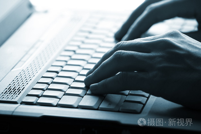 男性手上一台手提电脑打字