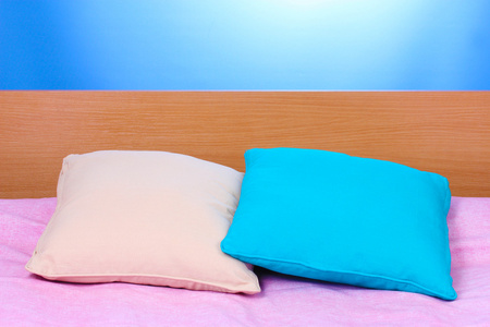 明亮在蓝色背景上的床上的枕头