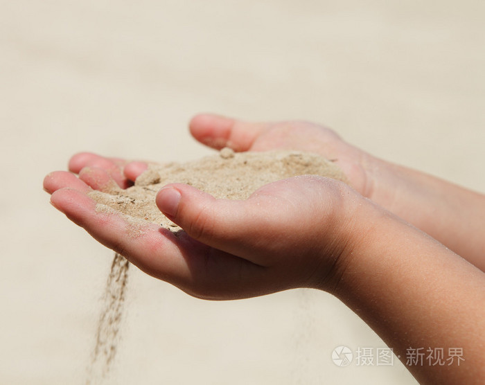 手中持有沙子的孩子