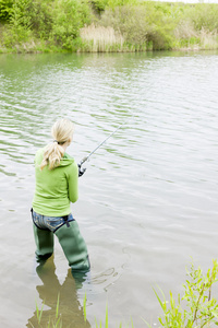 在池塘里钓鱼的女人