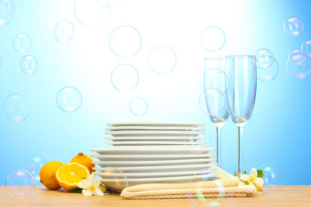 空清洁板和眼镜和柠檬在蓝色背景上的木桌上