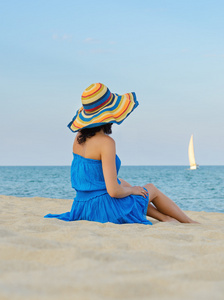 在沙滩上的一顶帽子的女人