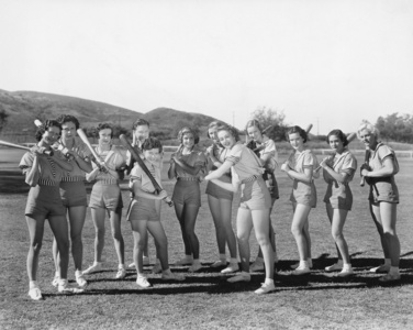 群妇女举行棒球棒和站成一排