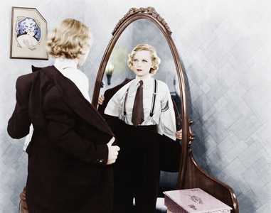 年轻女人在男人的衣服在镜子面前