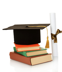 grad 帽子和文凭与书上白色隔离
