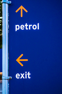 蓝色背景上的汽油加油站标志方向