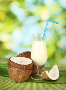 杯椰子牛奶和椰子上绿色背景特写