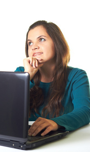 有吸引力的年轻微笑女孩在笔记本电脑工作的蓝色衬衫