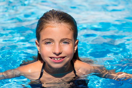 蓝眼睛的孩子在水表面的池脸的女孩