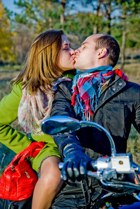 美丽的夫妇坐在自行车和亲吻