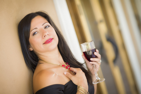 有吸引力的西班牙裔女人肖像外享受酒